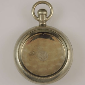 Può includere: Orologio da tasca in argento con cassa rotonda e fondello a cerniera. Il fondello è aperto, rivelando il meccanismo dell'orologio.