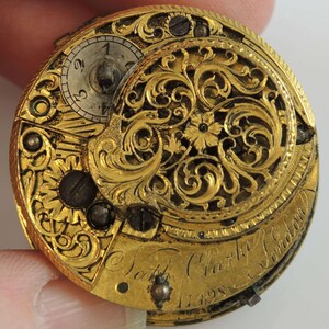 May include: A gold pocket watch with intricate floral engravings and the inscription "Nath. Clarke London 11498".