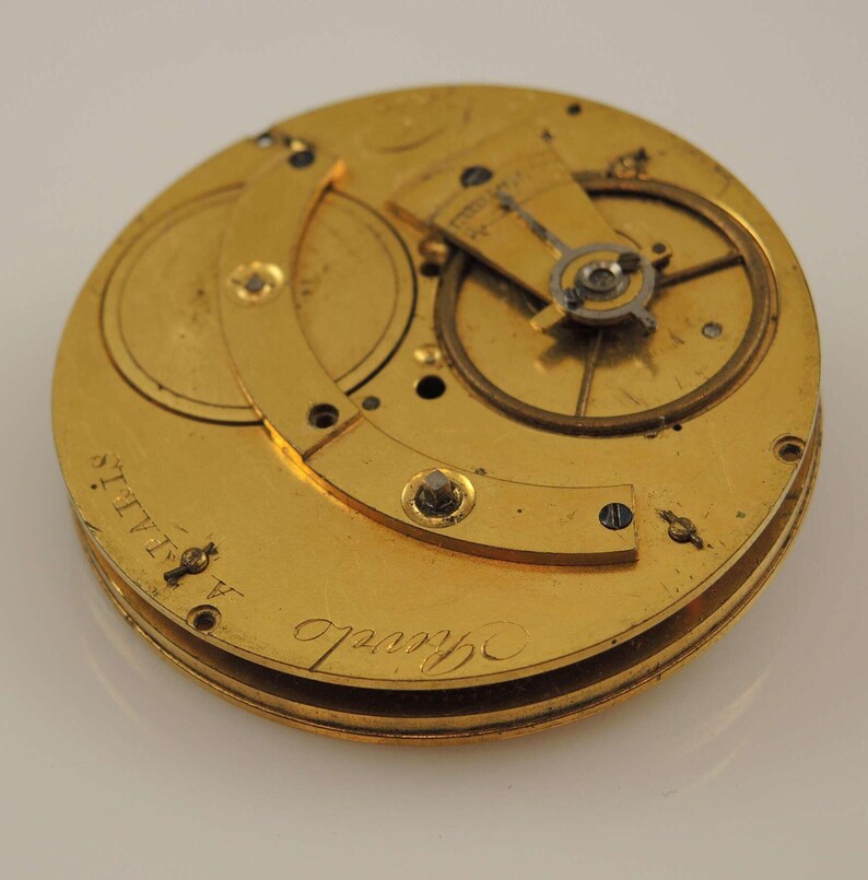 May include: A gold pocket watch movement with intricate gears and a circular plate with the inscription "Saville" and "A. HALLS."