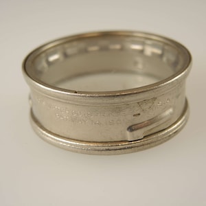 Puede incluir: Un anillo de caja de reloj de metal plateado con la inscripci&oacute;n "The Watch Co. of  S.F.  K.G.  U.S.A. Pat. May 14, 1902".