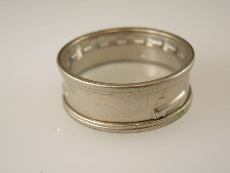 Puede incluir: Un anillo de plata con un dise&ntilde;o decorativo alrededor de la banda.