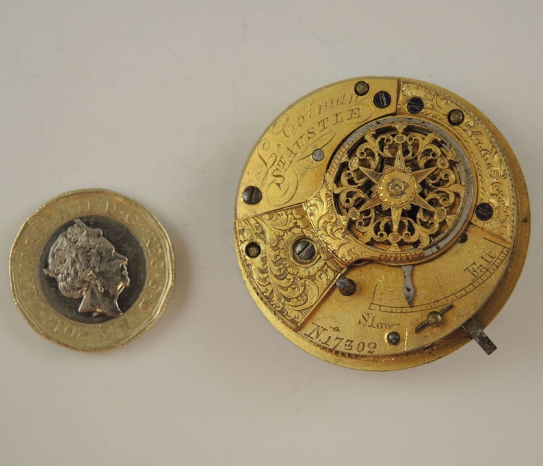 May include: Gold pocket watch with intricate engravings and a detailed clock face. The watch face has the inscription "Le Coultre" and "Seastle" and the number "N.17302".