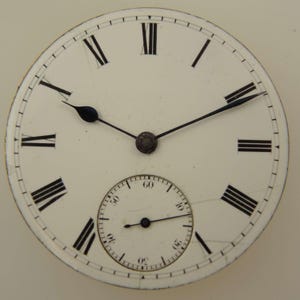 Pu&ograve; includere: Primo piano di un quadrante di orologio da tasca vintage. Il quadrante bianco presenta numeri romani neri, un quadrante dei secondi pi&ugrave; piccolo e lancette nere. Il quadrante ha un'estetica classica e antica.