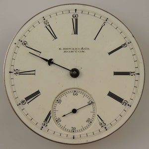 K&ouml;nnte beinhalten: Ein wei&szlig;es Taschenuhrenglas mit schwarzen r&ouml;mischen Ziffern f&uuml;r die Stunden und schwarzen Markierungen f&uuml;r die Minuten. Das Zifferblatt der Uhr hat einen kleineren, konzentrischen Kreis mit schwarzen Minutenmarkierungen und einem schwarzen Zeiger. Das Zifferblatt der Uhr tr&auml;gt au&szlig;erdem den Text "E. HOWARD & CO. BOSTON."