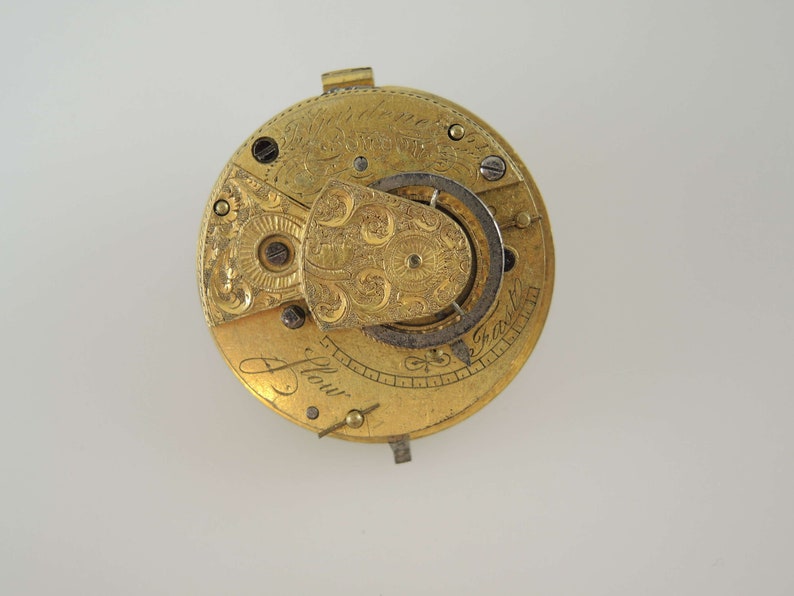 K&ouml;nnte beinhalten: Eine goldene Taschenuhr mit aufwendigen Gravuren und der Inschrift "J. Flow" auf dem Zifferblatt.