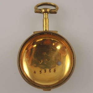 Könnte beinhalten: Geöffnete goldene Taschenuhr-Hülle mit glänzendem, goldenem Innenraum. Die Zahlen "43368" sind sichtbar. Die Uhr hat oben eine Schlaufe für eine Kette.