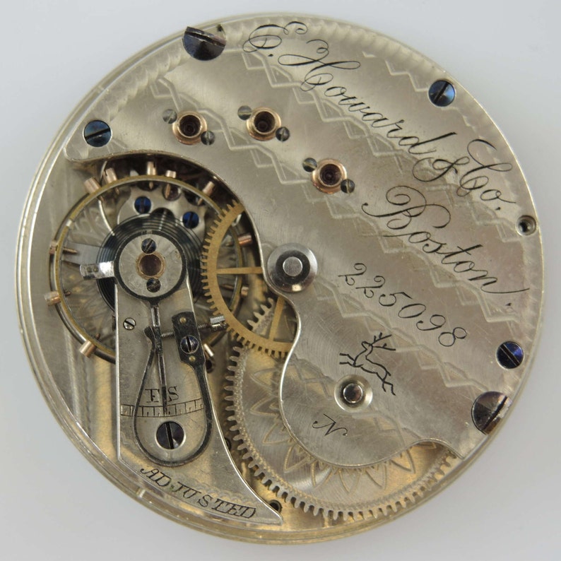 K&ouml;nnte beinhalten: Nahaufnahme des Innenlebens einer silbernen Taschenuhr mit der Inschrift "E. Howard & Co. Boston" und der Nummer "225098".
