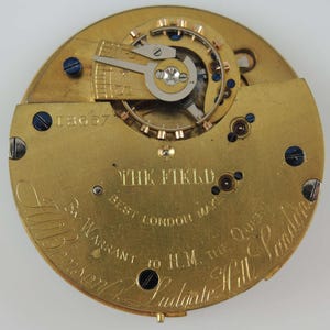 May include: A gold pocket watch movement with the inscription "The Field Best London Maker By Warrant to H.M. The Queen" and the number "18637".