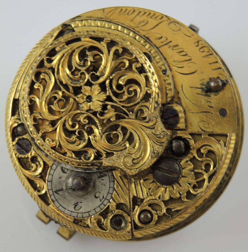 May include: A gold pocket watch with intricate floral engravings and the inscription "James Clark 1783 London".