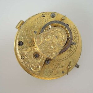 K&ouml;nnte beinhalten: Eine goldene Taschenuhr mit aufwendigen Gravuren und einem detaillierten Mechanismus. Das Zifferblatt der Uhr ist mit "J. Flower" und "Chas. Jenner" signiert.