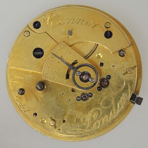 Puede incluir: Primer plano de un movimiento de reloj de bolsillo de oro con la inscripci&oacute;n "E. Connor London" y el n&uacute;mero "3341".