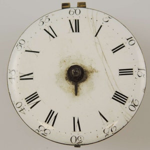 May include: White clock face with black Roman numeral hour markers and black minute markers. The clock face is cracked.