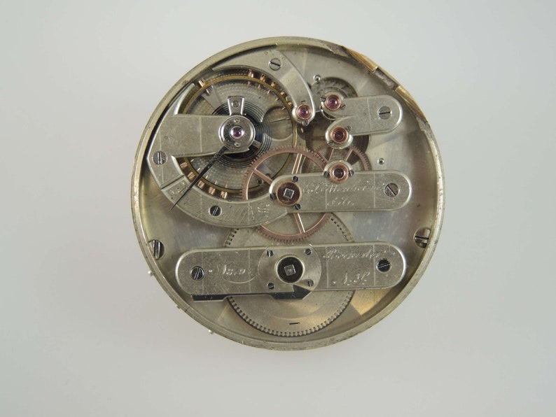 May include: Close-up view of the inner workings of a silver pocket watch. The watch face is visible with intricate gears and levers. The text "W. Ditfurth & Sohn, St. Gallen" is visible on the watch face.
