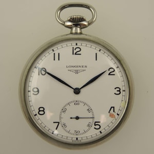 May include: A silver Longines pocket watch with a white face, black hands, and black numerals. The watch has a subdial for seconds and a loop at the top. The word "SWISS" is at the bottom.