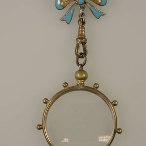 Victorian gilt metal and enamel bow pin with frame locket c1890