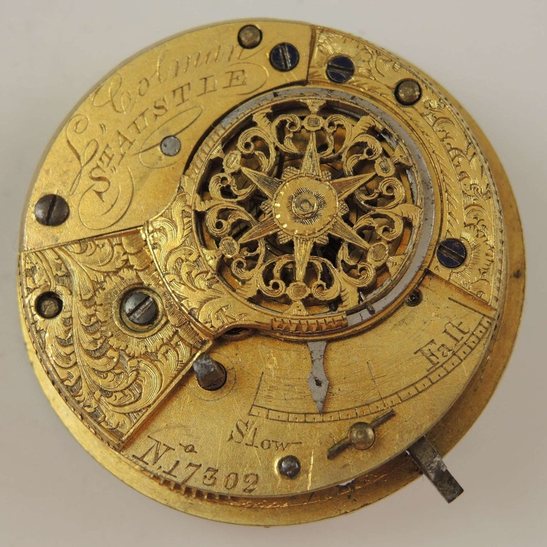 May include: Close-up of a gold pocket watch with intricate engravings and a detailed mechanism. The watch face features the inscription "London's  S.Austle" and the number "N.17302".