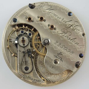 K&ouml;nnte beinhalten: Nahaufnahme des Innenlebens einer silbernen Taschenuhr. Die Uhr ist mit "E. Howard & Co. Boston" und "255098" gekennzeichnet.