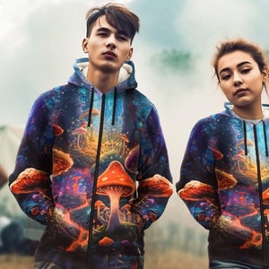 May include: Two people wearing black zip-up hoodies with a psychedelic mushroom print. The print features a variety of colorful mushrooms, glowing lights, and a dark blue background.