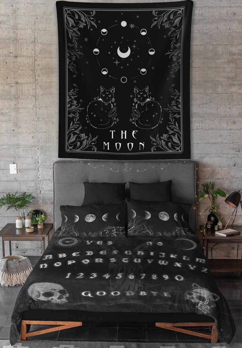 May include: Black and white tapestry with a moon and stars design. Two black cats are sitting on either side of the text "THE MOON".