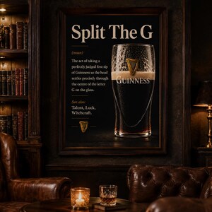May include: A framed print with the text "Split The G" and a definition related to Guinness. The image features a pint of Guinness, a dark stout, with a creamy head. The setting is a dimly lit room with leather furniture and a bookshelf.