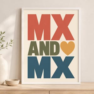 May include: A framed wall art print featuring the text MX AND MX in bold, blocky letters. The top MX is red, the middle AND is olive green, and the bottom MX is dark blue. A yellow heart icon is positioned to the right of the word AND.
