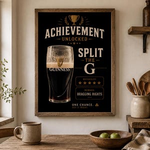 Puede incluir: Un p&oacute;ster negro enmarcado con una pinta de Guinness y el texto "ACHIEVEMENT UNLOCKED SPLIT THE G". El p&oacute;ster tambi&eacute;n incluye el texto "Difficulty: ***** Reward: Bragging Rights" y "One Chance. Get it Right."