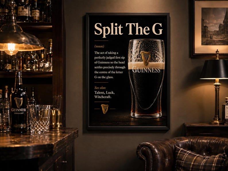May include: A framed black and white Guinness advertisement with the text "Split The G" and a definition. The image features a pint of Guinness and the Guinness logo. The background includes a bar setting with bottles and glasses.