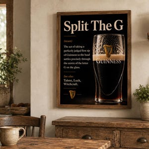 May include: A framed print with the text "Split The G" and a definition. The image features a pint of Guinness stout with the Guinness logo. The print is displayed in a rustic kitchen setting.