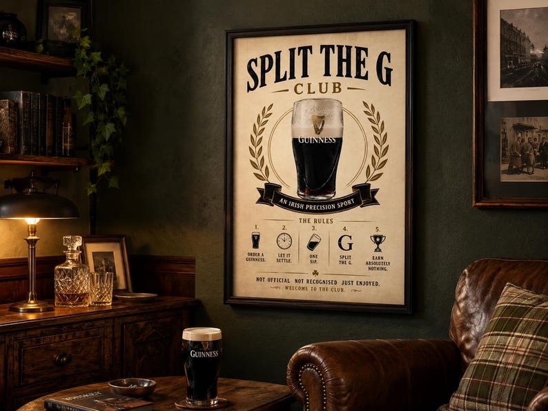 May include: A framed Guinness poster with a pint of Guinness in the center, surrounded by a laurel wreath. The poster reads "Split the G Club" and "An Irish Precision Sport." Below are the rules for enjoying Guinness. A pint of Guinness sits on a table.