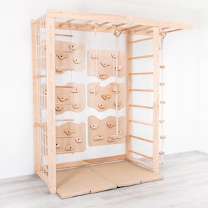 Puede incluir: Un marco de escalada de madera con múltiples elementos para jugar y hacer ejercicio. Incluye una pared de escalada con presas, una escalera de cuerda, una escalera horizontal, un columpio de cuerda y una red. El marco es de madera clara y se apoya en una colchoneta acolchada.