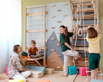 May include: An indoor climbing frame for children, featuring a wooden ladder, climbing wall, and rope net. The room has soft mats and colourful cube seats. Children are playing and reading in the play area.