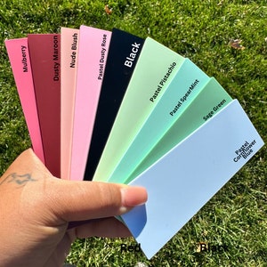 May include: A fan of color swatches in various shades of pink, green, blue, and red. The swatches are labeled with names like "Mulberry", "Dusty Maroon", "Nude Blush", "Pastel Dusty Rose", "Black", "Pastel Pistachio", "Pastel SpearMint", "Sage Green", and "Pastel Cornflower Blue".