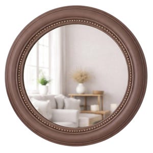 Pode incluir: Um espelho de parede circular com uma moldura castanha mate lisa e uma borda interior decorativa de pequenos detalhes em relevo semelhantes a contas. O vidro do espelho &eacute; transparente e reflete um interior luminoso e desfocado.