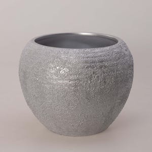 Könnte beinhalten: Ein silberfarbener, strukturierter Keramik-Pflanztopf mit runder Form. Der Pflanztopf hat eine breite Öffnung und eine raue, gesprenkelte Oberfläche. Der Innenraum ist ein dunklerer Silberton. Geeignet für den Innen- oder Außenbereich.