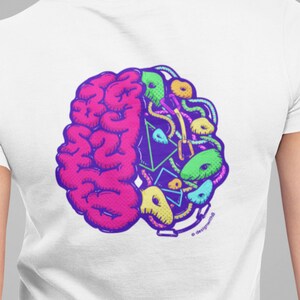 Könnte beinhalten: Weißes T-Shirt mit einer bunten Grafik eines Gehirns mit Klettergriffen auf einer Seite. Die Grafik ist in einem Kreis und hat ein Copyright-Symbol am unteren Rand.