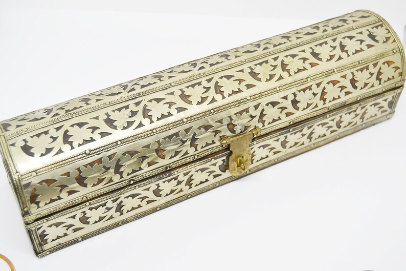 May include: A silver and brown decorative box with intricate floral patterns and a brass lock.