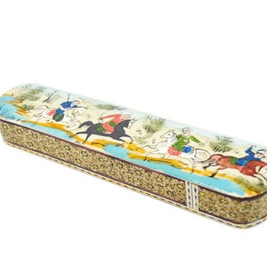 Puede incluir: Una caja larga y rectangular con un dise&ntilde;o colorido pintado a mano que representa a personas montando a caballo. La caja est&aacute; hecha de madera y tiene un patr&oacute;n decorativo intrincado alrededor de los bordes.