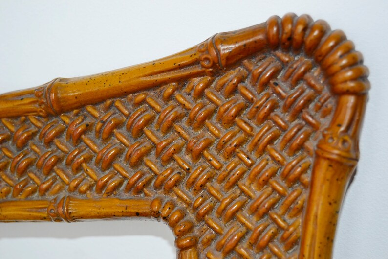 May include: Close-up of a woven bamboo chair back with a brown and orange colour scheme. The woven pattern is intricate and detailed.
