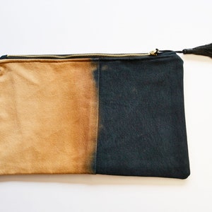 May include: A black and tan canvas zippered pouch with a black tassel.
