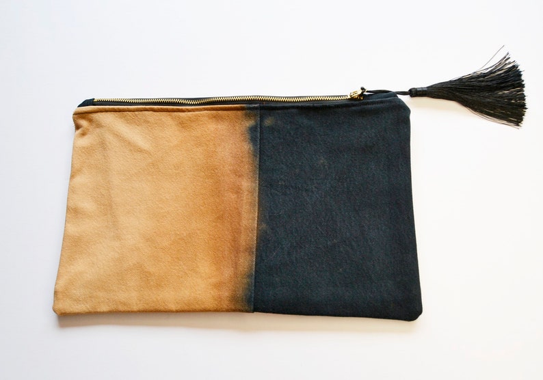 May include: A black and tan canvas zippered pouch with a black tassel.
