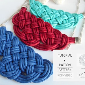 以下が含まれることがあります： 青、赤、ターコイズの3つの結び目のロープネックレス。ネックレスは太いロープで作られており、両端に銀色のチェーンが付いています。ネックレスは白い表面に置かれています。画像には「TUTORIAL Y PATRÓN PATTERN PDF+VIDEO」というテキストが表示されています。