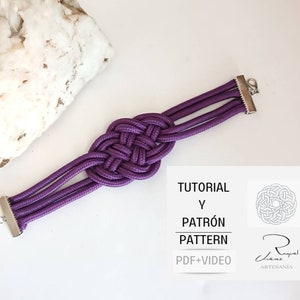 May include: Purple braided bracelet with a silver clasp. The bracelet is tied in a knot pattern. The image also includes a card with the text "TUTORIAL Y PATRÓN PATTERN PDF+VIDEO" and a small illustration of a knot.