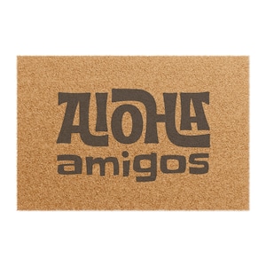 Peut inclure: Un paillasson en fibre de coco brun avec le texte "ALOHA amigos" en lettres noires.