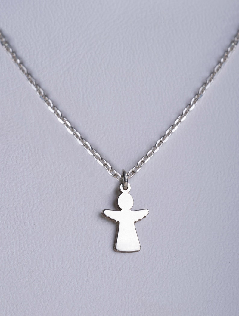 May include: A silver chain necklace with a small silver angel pendant.