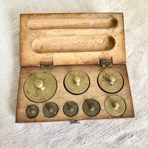 Antique brass weight set in wooden box early 1900s eight graduated apothecary weights