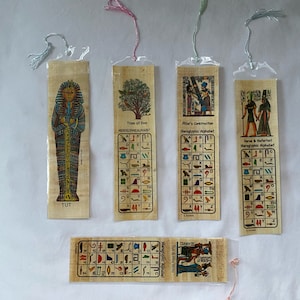 May include: A set of papyrus bookmarks with Egyptian hieroglyphs and illustrations. The bookmarks show images of Tutankhamun, trees, and pharaohs, with text including "TUT" and "Hieroglyphic Alphabet". Each bookmark has a colourful tassel.