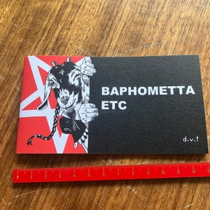 May include: A black and red booklet with a black and white illustration of a goat with a pentagram on the cover. The text "Baphometta ETC" is printed in white on the cover. The text "d.v.t" is printed in white in the bottom right corner.