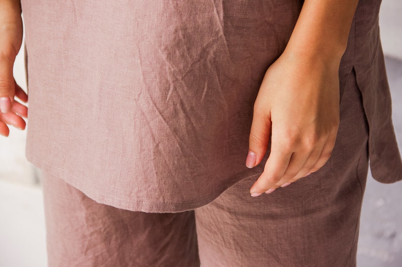 Op de afbeelding: Een mauve linnen top en broek set. De top heeft een ontspannen pasvorm en een licht gebogen zoom. De broek heeft een rechte pijp.