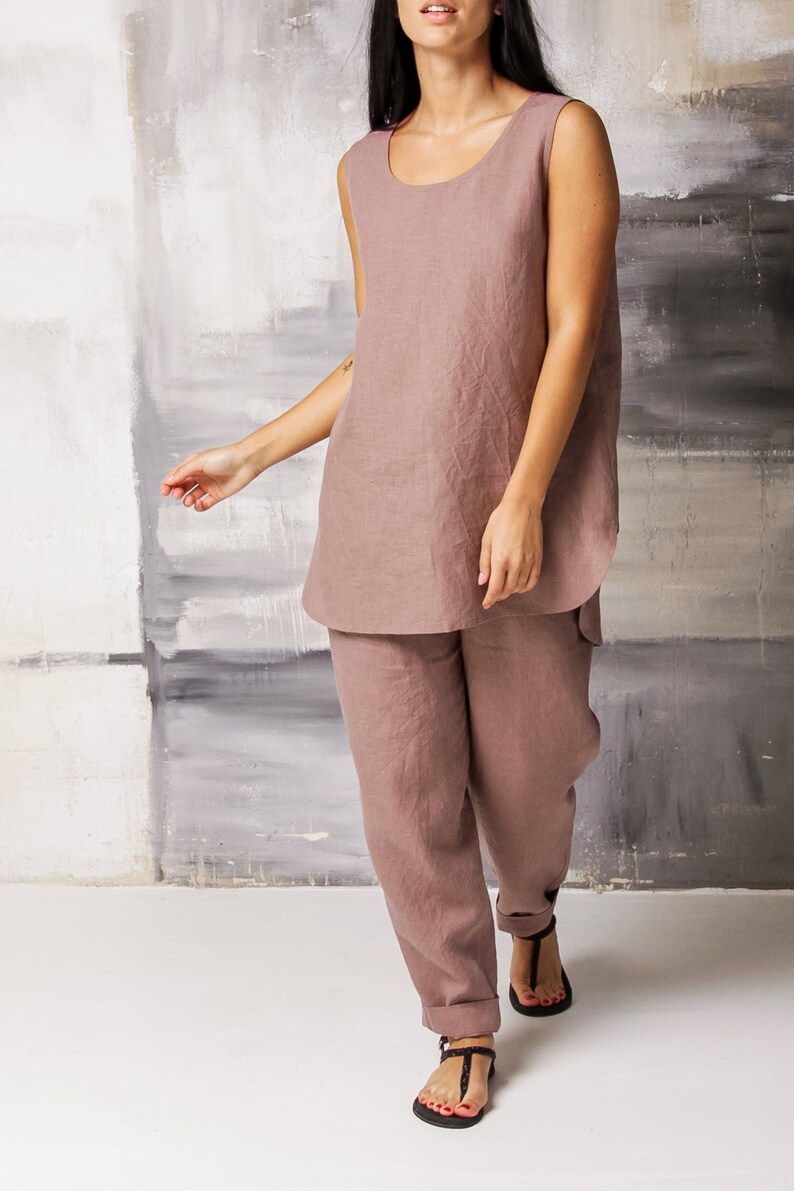 Op de afbeelding: Een mauve linnen tanktop en bijpassende broek. De outfit is losjes gesneden en heeft een ontspannen, casual stijl.