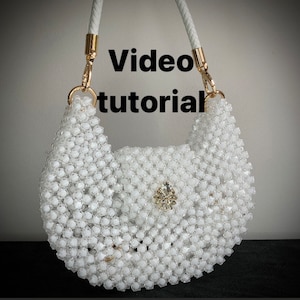 May include: White beaded handbag with a gold chain strap and a rhinestone embellishment. Video tutorial.